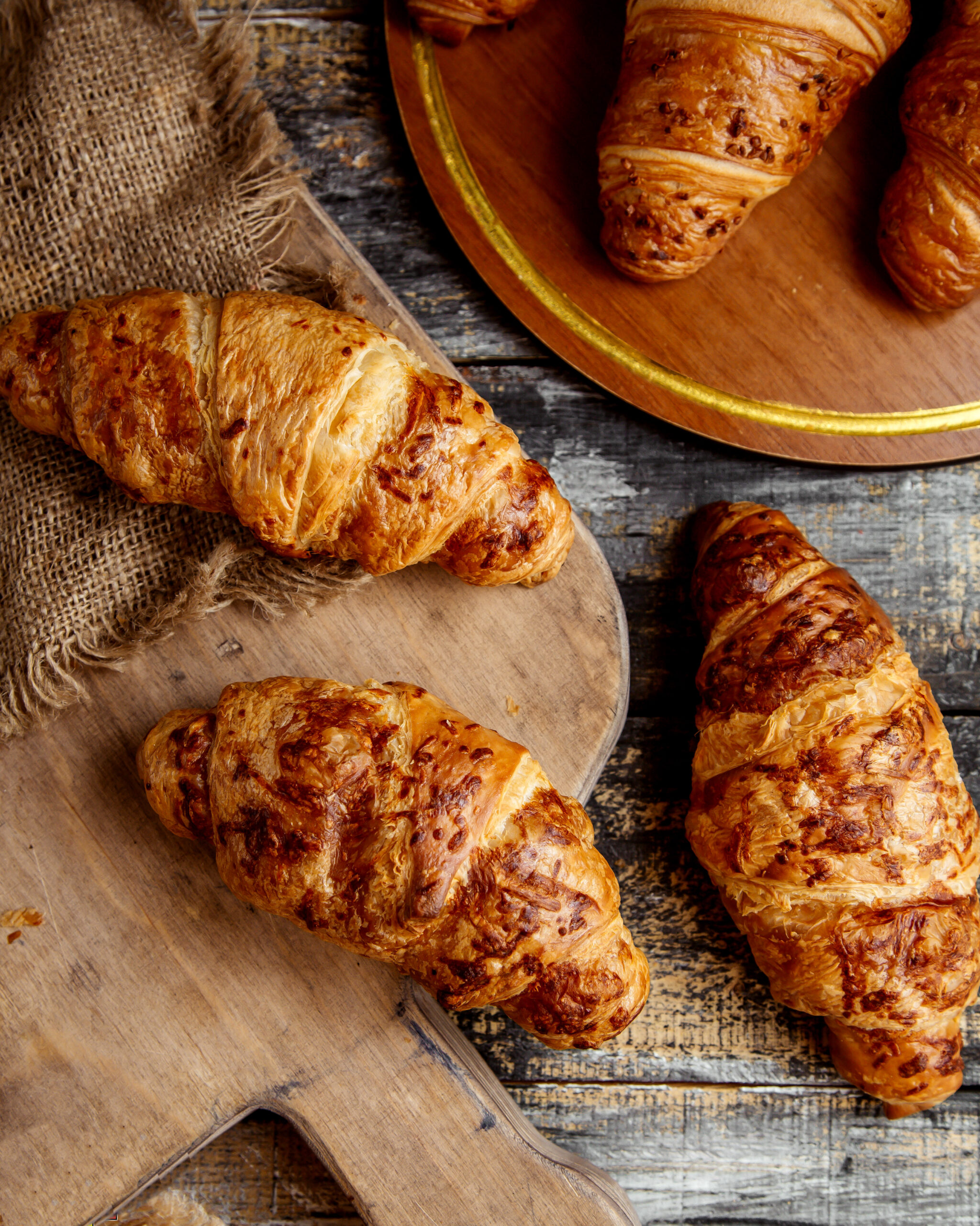 top view of butter croissants placed on wooden board