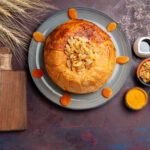 top-view-shakh-plov-delicious-eastern-meal-consists-cooked-rice-inside-round-dough-dark-background-cuisine-meal-rice-food-dough
